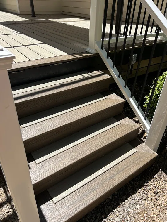 Composite deck steps with black metal balusters and a white rail, built by The handyman in Griffin GA