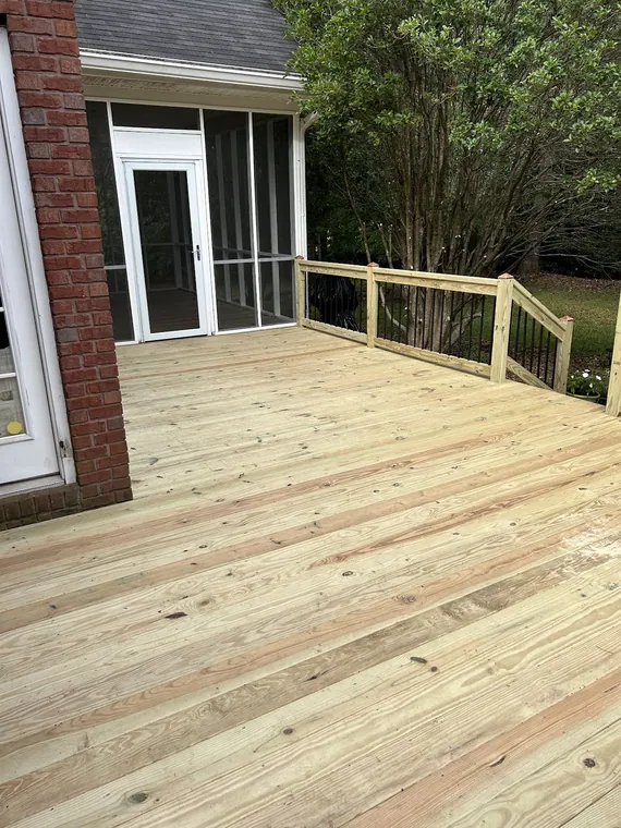 Newly built wood deck beside a brick wall