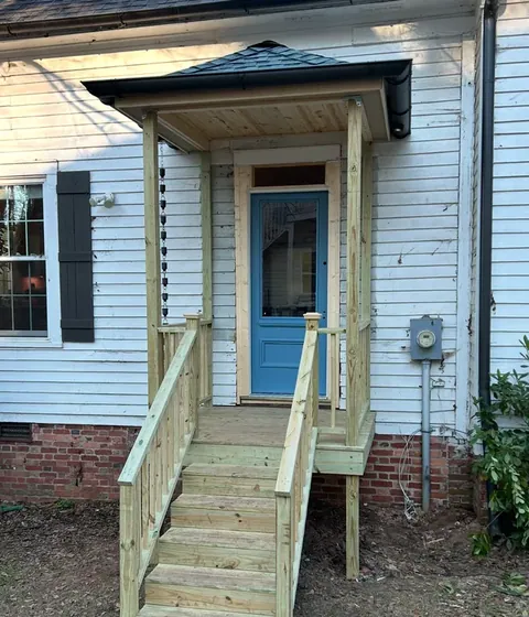 Porch steps and handrail leading to a front door